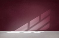 Burgundy red wall in an empty room with concrete floor