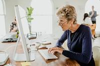 Senior woman typing on a computer keyboard