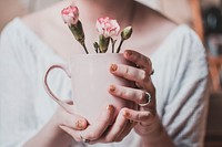 Free woman holds pink flower cup image, public domain people CC0 photo.