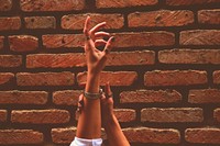 Free hands reach upwards with brick wall background image, public domain CC0 photo.