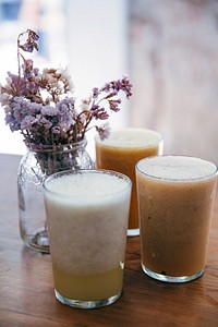 Free smoothies with flower vase on wooden table photo, public domain beverage CC0 image.