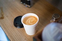 Free latte art cup on wooden table photo, public domain beverage CC0 image.
