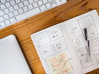 Free sketchbook and keyboard on wooden table photo, public domain CC0 image.