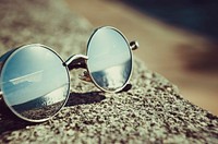 Free sunglasses by beach photo, public domain CC0 image.