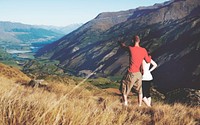 Couple looking afar where the mountain and lake are.