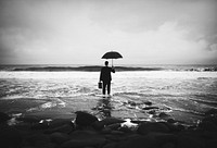 Businessman with an umbrella at a stormy ocean