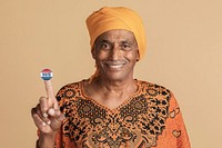 Mixed Indian senior man in a yellow turban showing a vote sticker