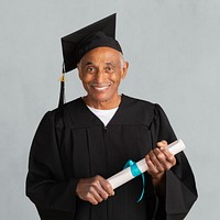 Senior man in a graduation gown holding his master&#39;s degree mockup