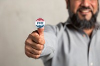 Bearded Indian man showing a vote sticker