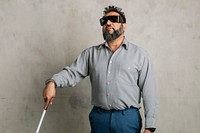 Blind Indian man wearing black goggles and using a white cane 