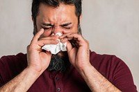 Sick Indian man blowing his nose 