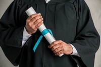 Student in a graduation gown holding his diploma 