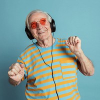 Happy senior man dancing while listening to music with headphones