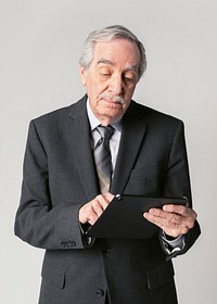 Busy senior businessman using a digital tablet 