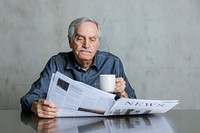 Senior man reading the news and drinking coffee