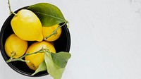 Fresh lemons in a black bowl flatlay