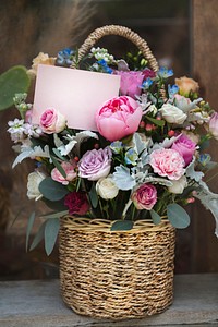 Basket filled with assorted colorful flowers and a notecard