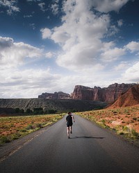 Man jogging on a desert road to a mountain