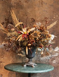 Bouquet of dry flowers in a vase by a grunge brown wall