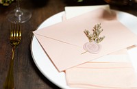 Floral stamped pink envelope on a plate