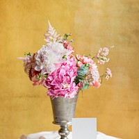 Flowers in a vase by a yellow wall