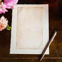 Vintage paper on a wooden table with flowers