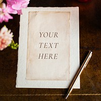 Vintage paper mockup on a wooden table with flowers