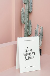 White poster on a pastel pink floor by cacti