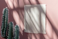 White poster template on a pastel pink wall by cacti