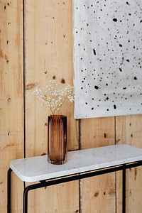 Marble table by an art piece on a wooden wall