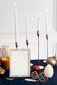 Christmas photo frame on a table with taper candles