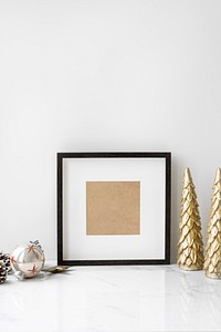 Picture frame on a table with golden Christmas tree