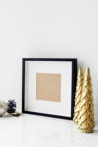 Picture frame on a table with golden Christmas tree