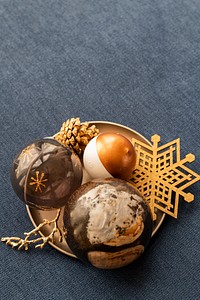 Festifve golden Christmas ornaments on a plate