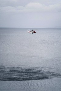 Coastguard helicopter flying over the sea in Scotland