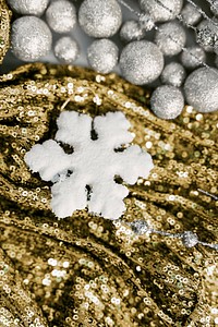 White snowflake ornament on gold sequin background