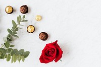 Round nutty chocolates by a red rose 