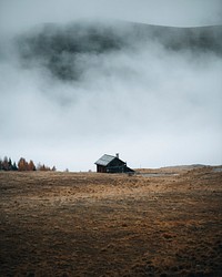 Hut by the curve road on a foggy hill