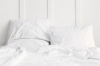 White bed linen on a bed in a white bedroom