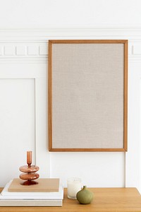 Picture frame hanging over a wooden sideboard table 