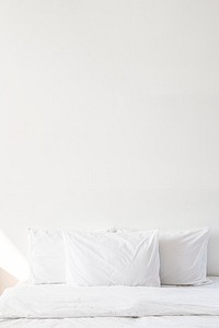 White bed linen on a bed in a white bedroom