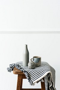 Gray ceramic vase with a mug on a wooden stool 