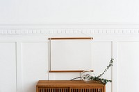 Blank frame hanging above a wooden cabinet