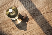 Glass water bottle on a wooden table aerial view