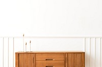 Taper candle holders on a wooden sideboard table 