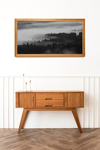 Picture frame mockup over a wooden sideboard table with taper candle holders