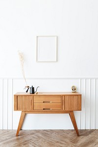 Picture frame above a wooden sideboard table with pour-over coffee maker and a black kettle 