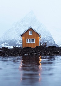 Yellow cabin in Sakrisoy overlooking Mount Olstind in Norway