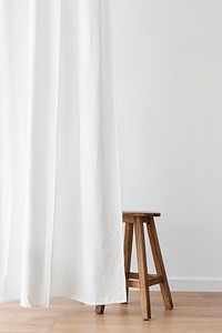 Wooden stool behind a white curtain
