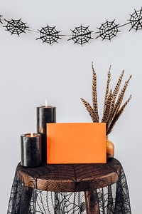 Orange Halloween card by the lighted candles 